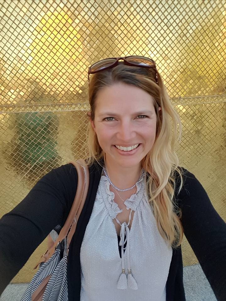 Nathalie Sameli lächelt vor einem goldfarbenen Hintergrund