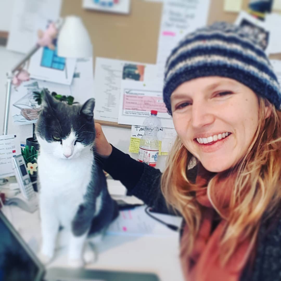 Nathalie Sameli mit Wollmütze neben ihrem schwarz-weissen Kater Lucky